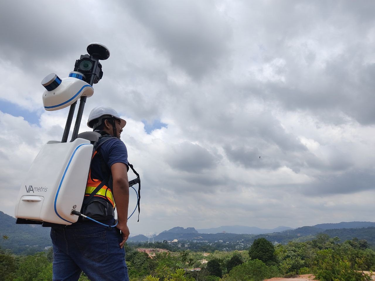 a man with backpack lidar sensor, walking, with the background of nature & the sky
